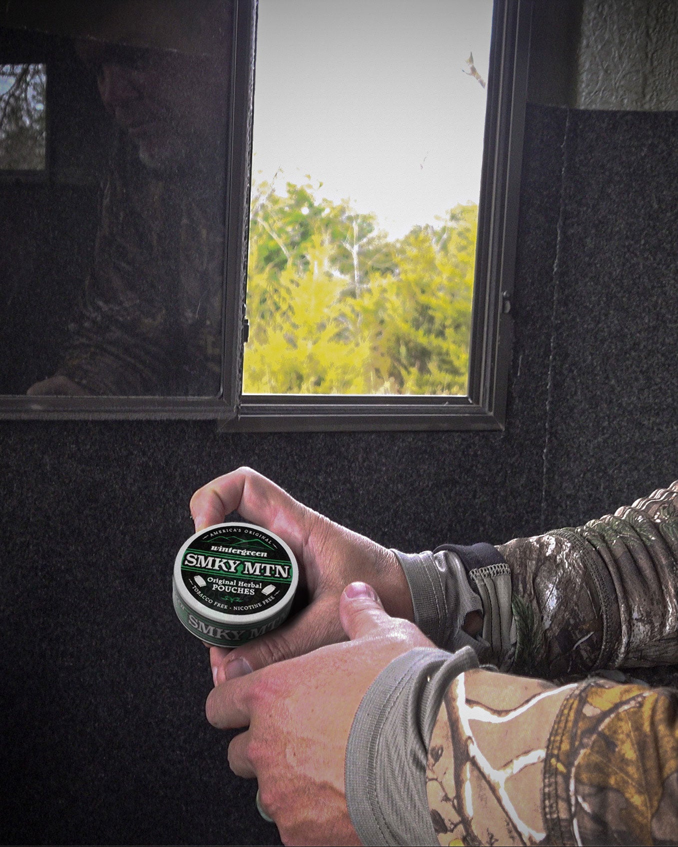 smokey mountain original pouched in chipper jones hand while in a hunting blind